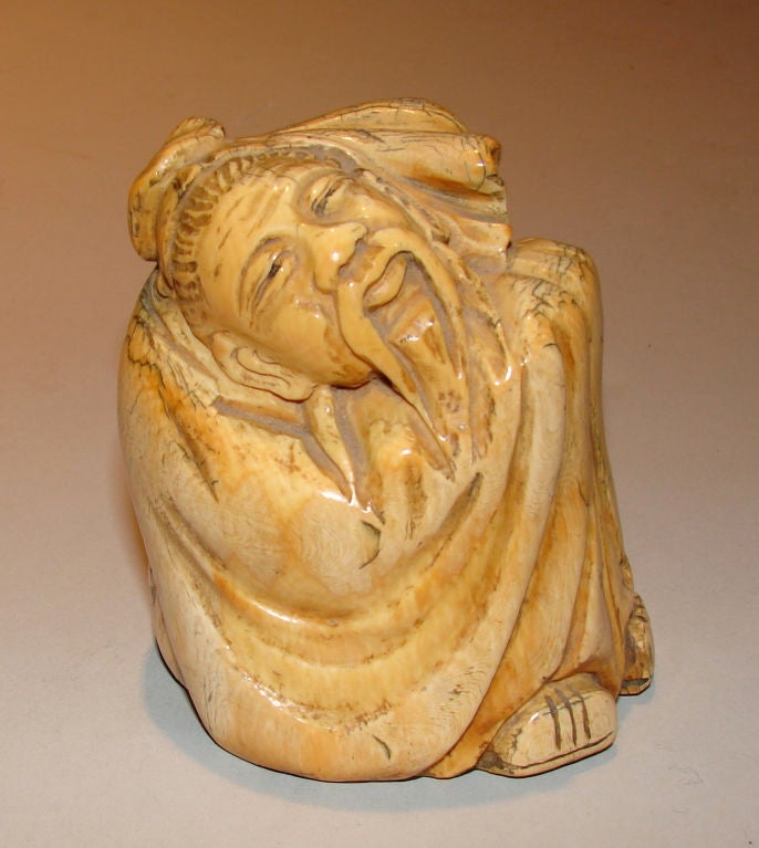A late nineteenth century Chinese patinated ivory carving of a seated elder in flowing robes. Signed on the base in Chinese characters.