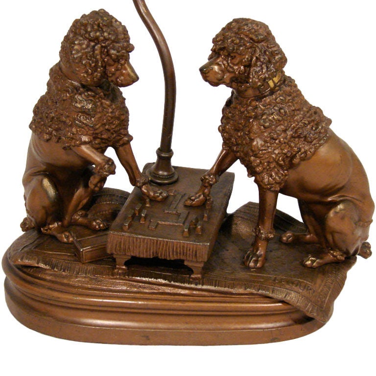An amusing patinated metal grouping of poodles playing dominoes, after a sculpture by Prosper Lecourtier (French School 1851-1924) dogs. Now as a table lamp.