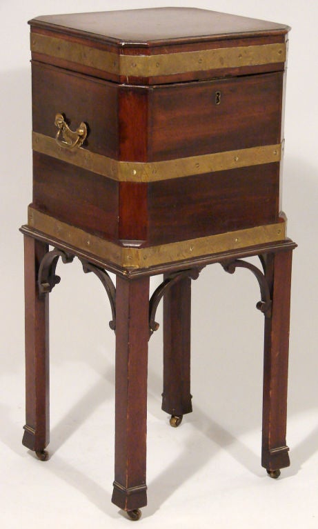A George III mahogany brass bound cellarette of small scale, the metal lined interior with 4 divides, resting on straight legs ending in marlborough feet with castors.
