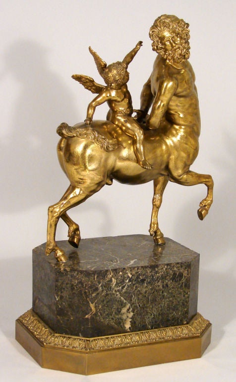 An impressive  cast brass sculpture of a centaur with putto mounted on a marble base with brass trim.