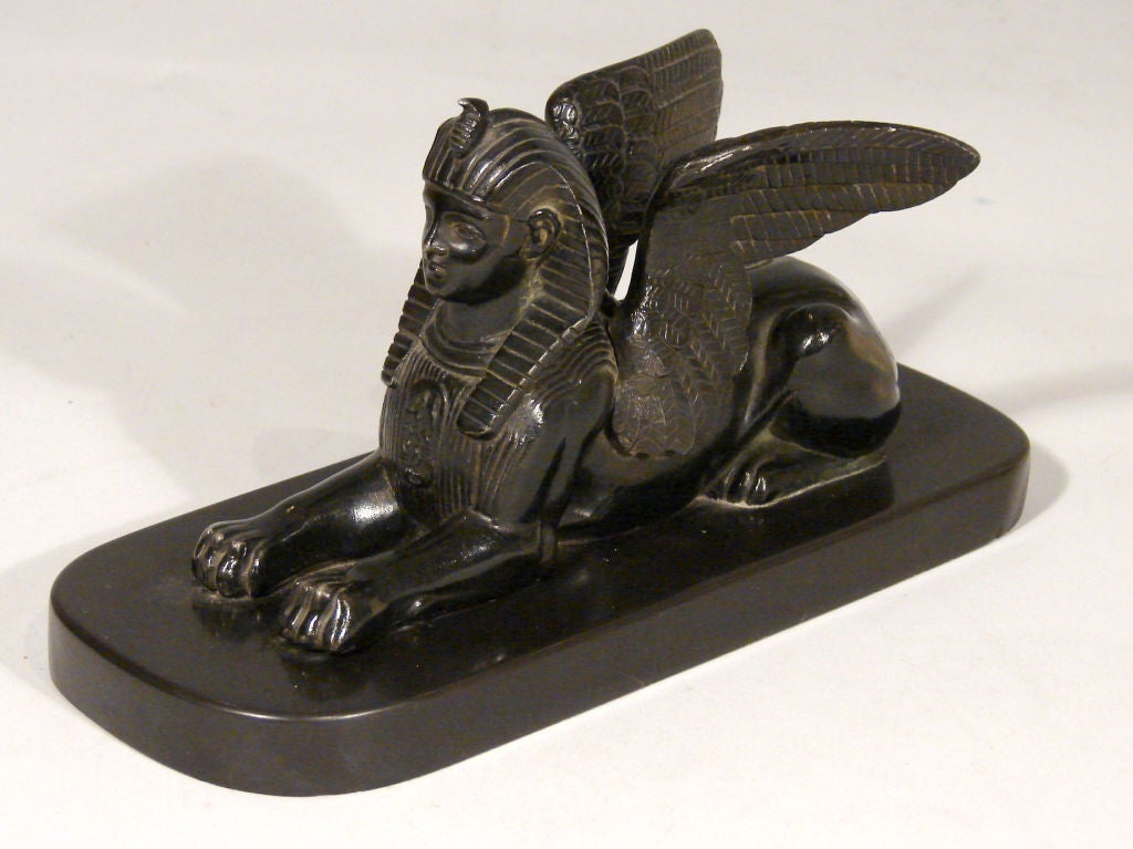 A Continental bronze winged sphinx on a dark marble base. Circa 1880-1900.
