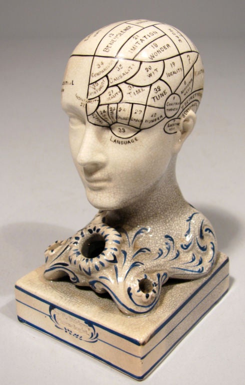 A Staffordshire pottery phrenology head pen stand inscribed with regions of the brain, on scrolled base and rectangular plinth impressed 
