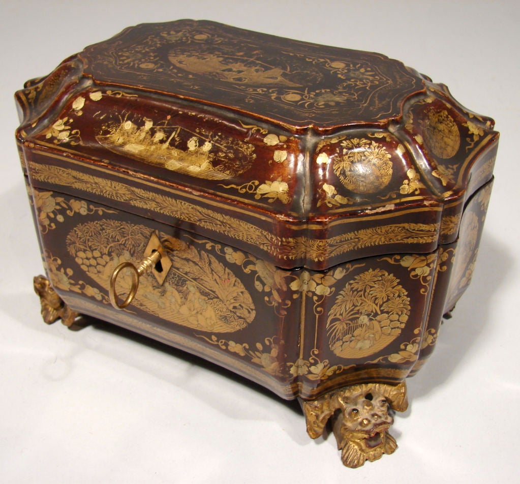 A Chinese export lacquer tea caddy of shaped outline decorated oval and circular figural reserve, the interior fitted with two putter canisters, all on winged dragon feet.