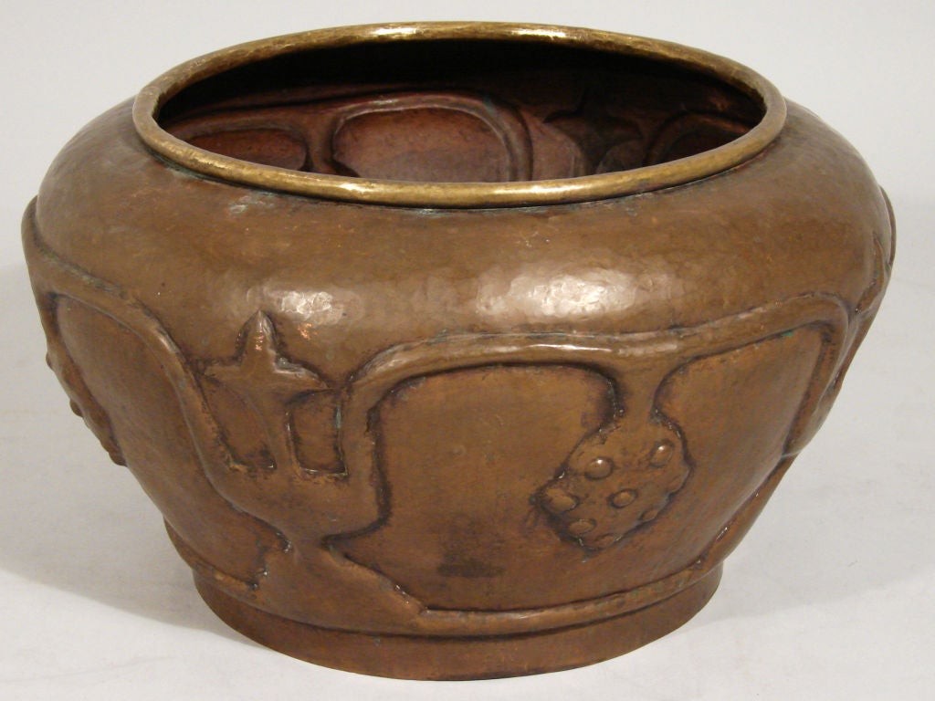 An attractive large scale arts and crafts period hammered copper planter with relief motifs and a rolled edge mouth. Probably American, circa 1900-1910.