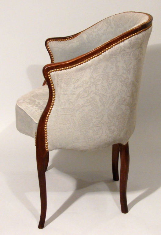 A charming pair of English mahogany tub chairs in the French Hepplewhite taste upholstered in pale blue damask. Twentieth century.