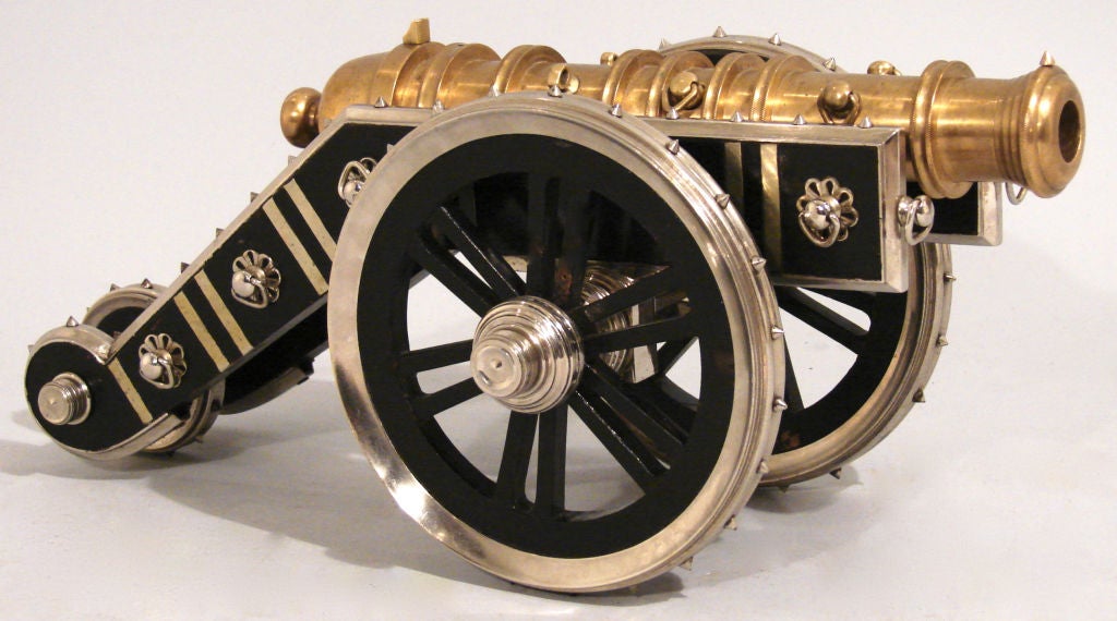 A very well-made machined brass and steel cannon, the hardwood carriage inset with floral decoration the studded wheels with wooden spokes and turned hubs. Twentieth century.