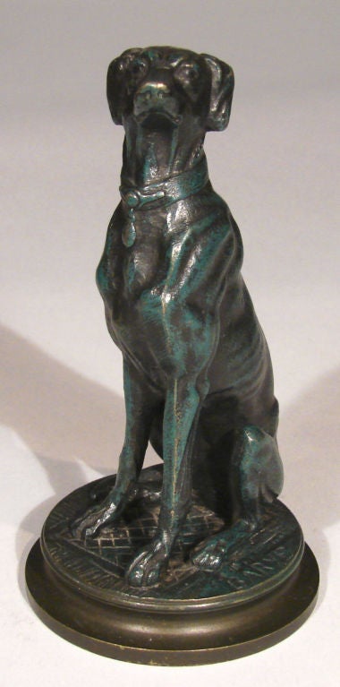 A bronze of a seated greyhound on a circular plinth after a model by Antoine Louis Bayre (1796-1875).