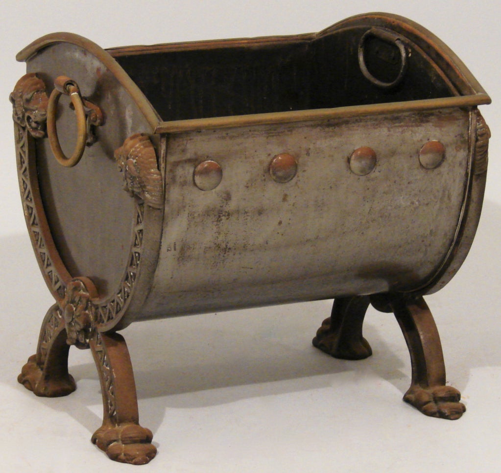 A fine Regency brass and steel log or coal bin of cylindrical form the ends framed by serpents.
