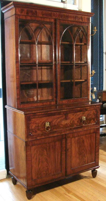 A Regency mahogany secretary bookcase the Gothic style glazed doors over a well fitted satinwood interior above 2 cupboard doors over reeded  toupie feet.