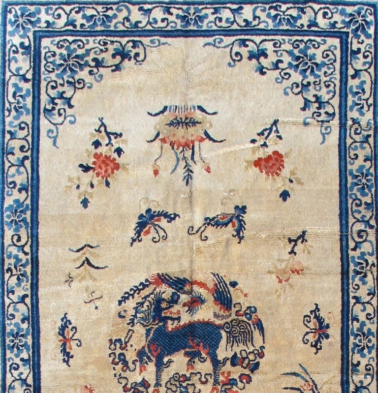 Symbols of love, abundance and good fortune adorn this Classic “small room-size” Chinese rug. The mythical Ki Lin, which symbolizes all that is good, is drawn in a central roundel. A delicately drawn vine-scroll and lotus design is traced in the