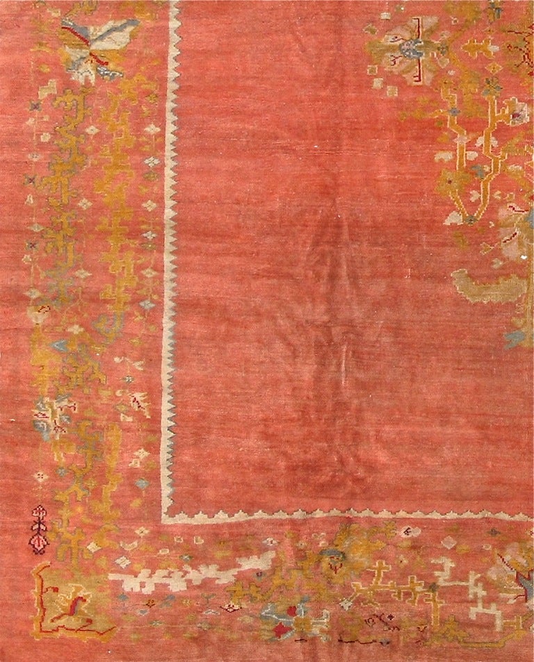 A plush Oushak with a deep warm open coral/salmon background offset by a largely acid-green border and medallion.