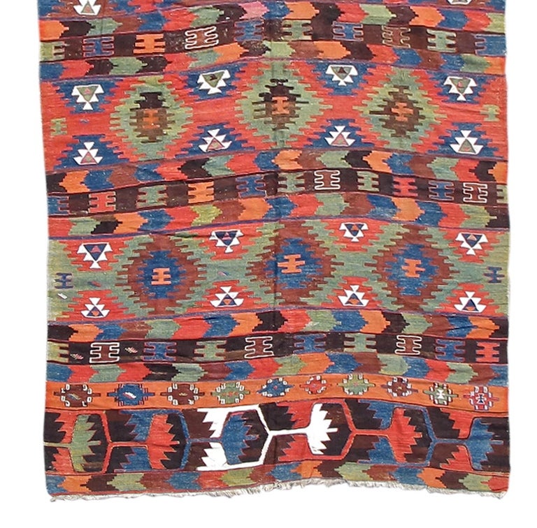 This richly colored flat-weave from the mountainous Elmadag region of northern Turkey uses a distinctive and deep palette unique to the Kilims of this region. While several darker shades of brown, brick reds, indigo blue and particularity a