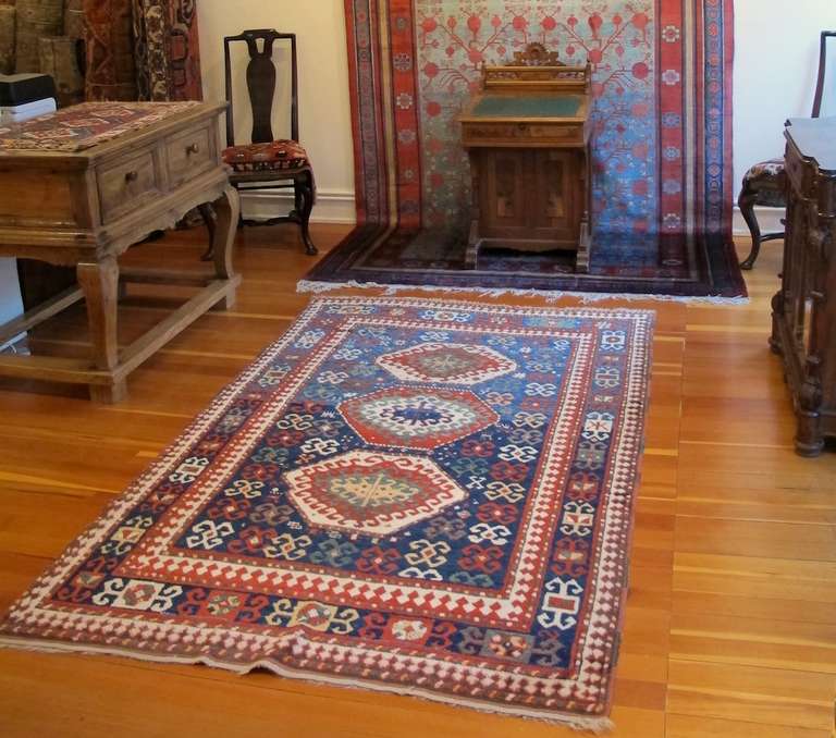A column of octagons organically drawn with repeat latch-hook design floats against the modulated indigo ground of this Bordjalou Kazak rug. The contrast of dark and medium blue in the field is evocative of a night and daytime sky with classic,