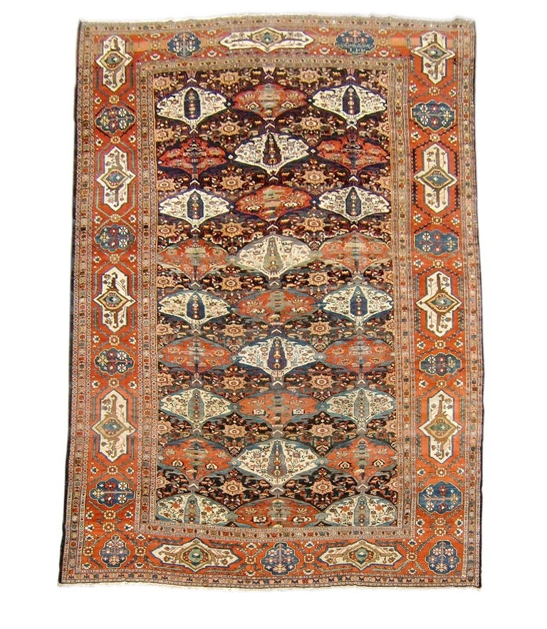 Elegantly drawn nine-tiered field of fan shaped medallions filled with cypress tree shapes, animal-like figures, and rosette flowers on vines. Lustrous wool and rich colors. The Persian script on the top of the rug says, â??In the order of Mr.