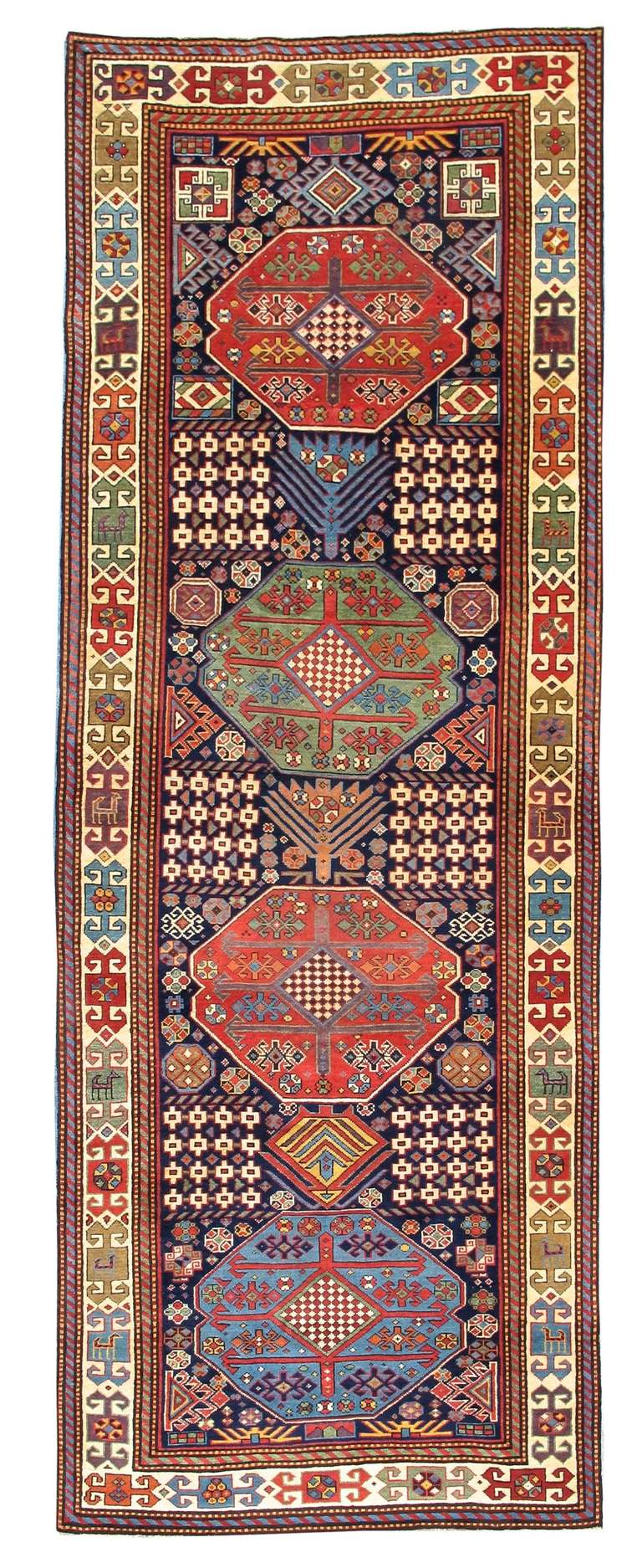 This Akstafa long rug is a perfect example of the free spirit which imbues great Caucasian village weaving. A row of large colorful medallions, each resembling tremendous floral bursts is drawn incorporating latch-hooks, checkered diamonds and the
