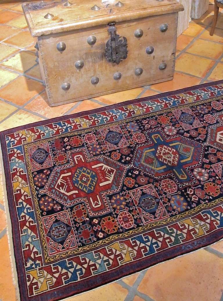 In the dynamic spirit of Caucasian rugs from the nineteenth century, this Shirvan piece seizes upon the underlying geometry of earlier Persian traditions and infuses them with a distinct local rendition of shapes and color. The central column of