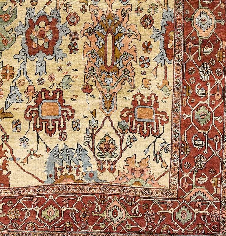 An arrangement of elegantly drawn alternating palmettes are drawn against the light ground of this square-shaped Heriz carpet. The lush drawing of ornament seems to reflect both classic Persian models as well as a definite neoclassical flare with