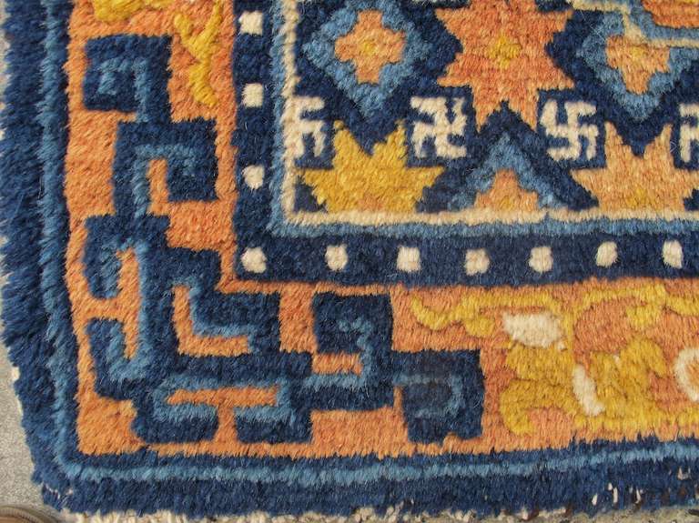 This fluffy Chinese seating square was most probably woven by ethnic Hui Muslim weavers in the area of Ningxia in northern China for a Buddhist religious institution somewhere in either China or Tibet. The inner medallion is composed of a garland of