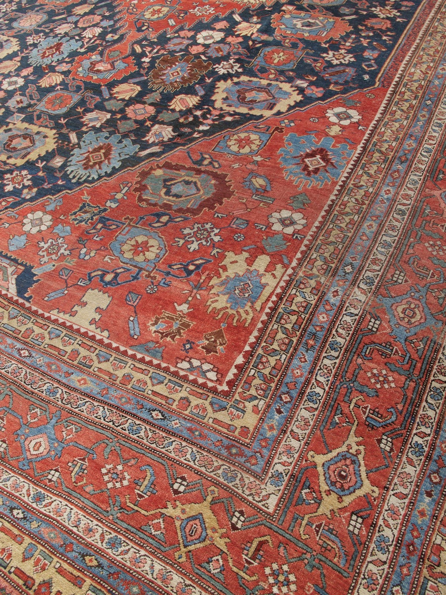 This magnificent over-sized Bidjar carpet combines two classic Northwest Persian field formats: a center medallion flanked by corner-pieces, as well as a harshang field design of repeating and alternating palmettes. Rather than competing for the