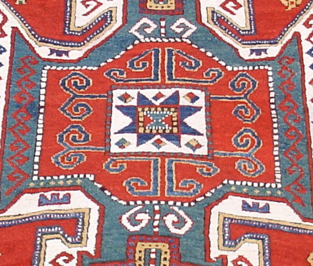 The Kazak “shield” design is one of the most iconic forms in Caucasian village weaving. Here it is excellently articulated in vibrant vegetal color. The bold contours of the top and bottom sectors of the central shield abstractly draw in very