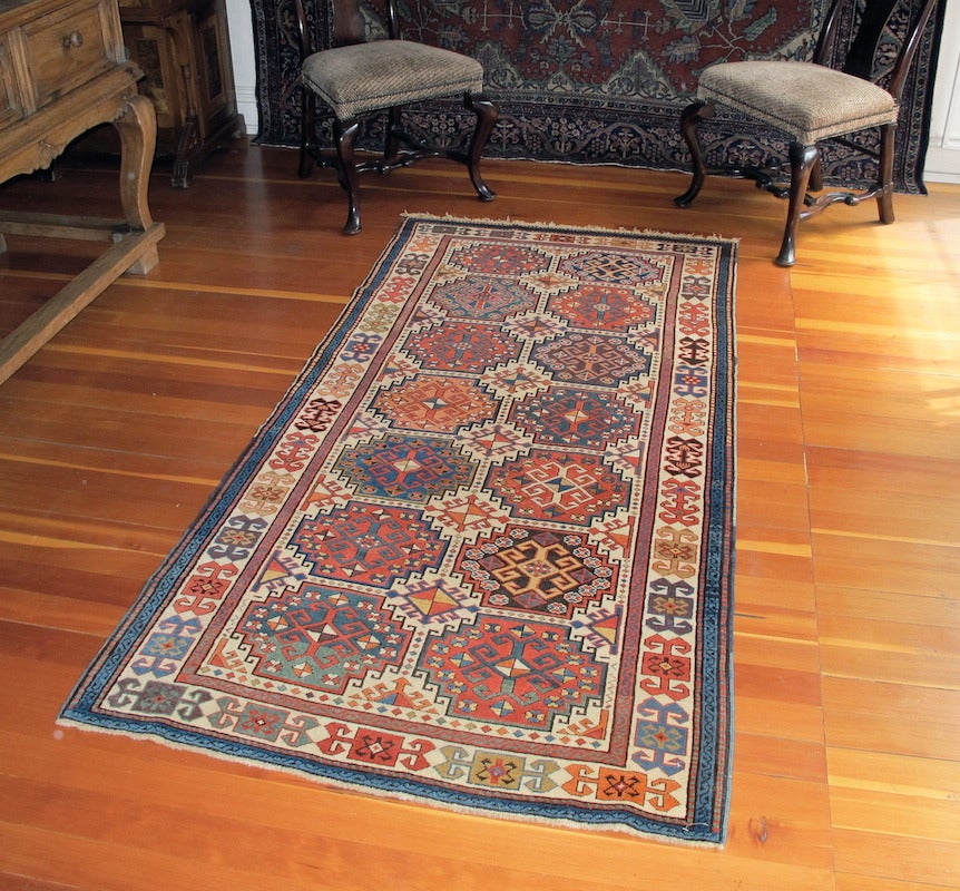 The so-called Memling gul is a favorite field device for Caucasian rugs and those with an ivory ground are particularly appealing. This Akstafa piece uses two columns of multi-colored Memling guls. Secondary columns of smaller Memlings are formed