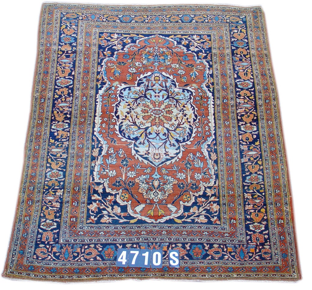 With perfect Persian style, this Tabriz carpet utilizes a classic medallion design. Alternating blue and red sections of the field and medallion are echoed in the border system, while the entire composition is further integrated by blossoming