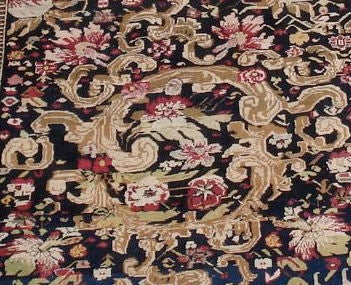 A European inspired design of realistically shaded acanthus scroll, roses and other flowers float amid large decorative golden swags on a black ground.This rug is in eccellent condition. 