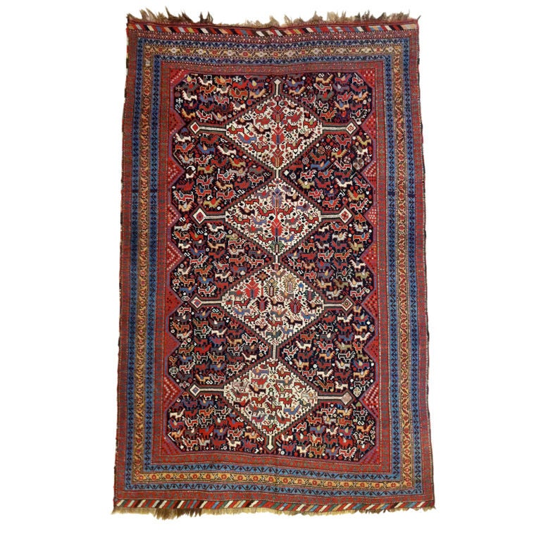 Pile rugs and saddlebags of the tribal peoples of Fars in southwest Persia are some of the most recognizable and desirable collectible weavings of any region. This charming Khamseh rug draws a column of four connected white diamonds against a deep
