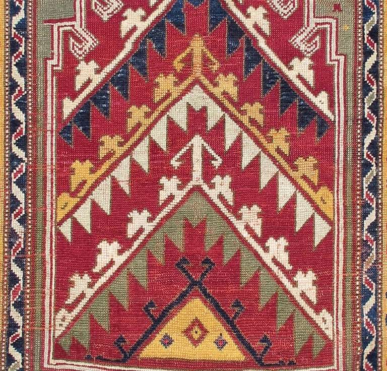 Weavers from Kirshehir, an area in north central Anatolia, are perhaps most well known for their prayer rugs, and this highly graphic colorful piece is a great reflection of this distinctive Turkish weaving heritage. The crenellated mihrab niche