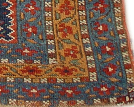 Wonderful example of sophisticated weaving on a tribal rug. Tribal geometrics evolved into organic flower forms float on an abrashed indigo blue field. A simplified but symmetrically cohesive herati design is carried around all three borders. Great