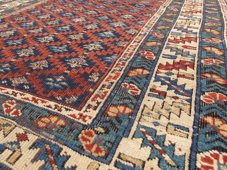 The careful use of red, blue and ivory set the tone for this Shirvan scatter. The red saw-toothed lattice creates a push-pull layering dynamic with the diamond shapes as the viewer tries to decide whether the field color is the blue receding into