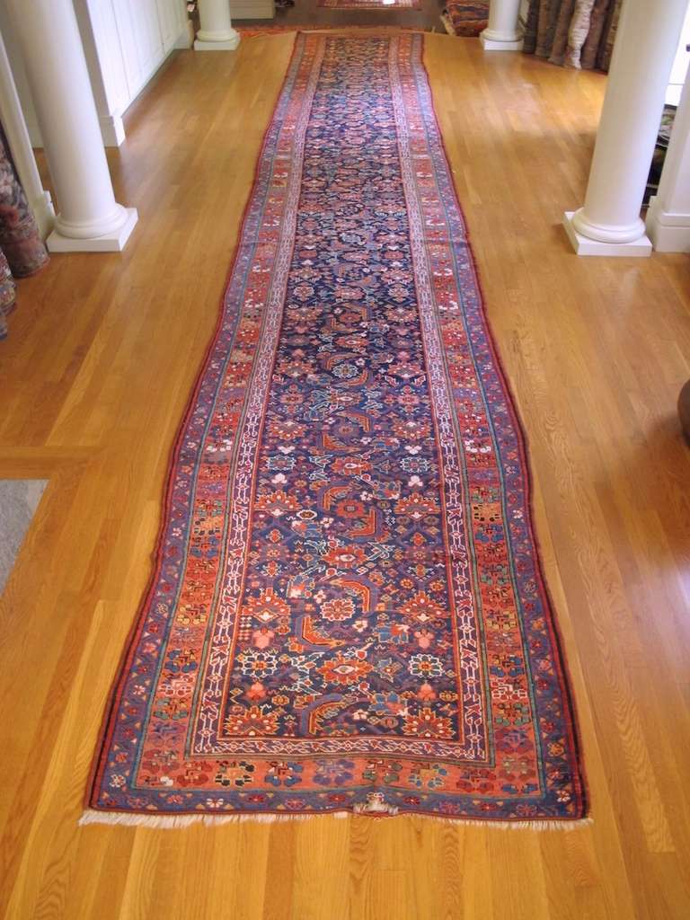 Kurdish weavings from the area of Sauj Boulag in Northwest Persia are renowned for their use of vivid and varied natural color and for their renditions of traditional 18th and 19th century Persian design using significant scale This piece uses