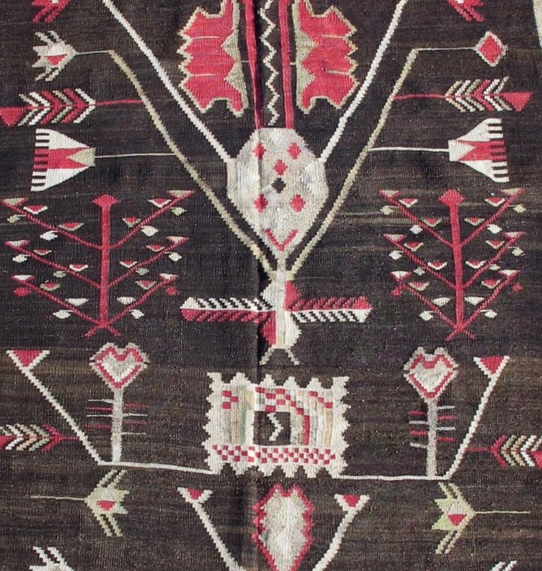 Like many Bessarabian kilims, this runner shows a synthesis of local folk motifs and designs inspired by 18th century French carpets popular at the Russian Court and in aristocratic circles. Here the floral elements are abstracted and simplified,