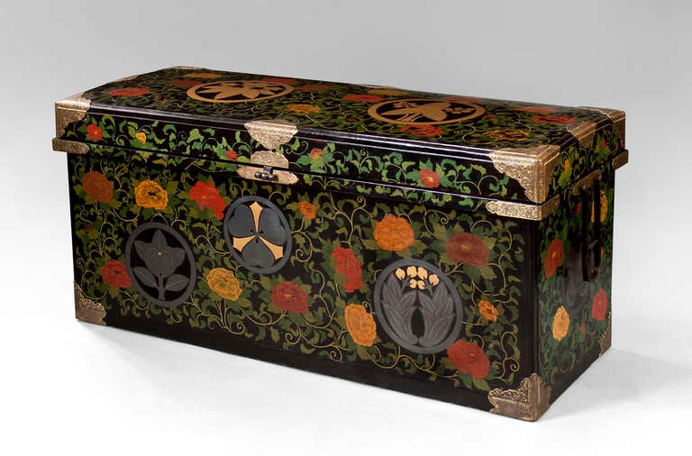 A rare polychromatic and richly exuberant nagamochi. The rectangular arched top, above a conforming base with two handles and gilt mounts embossed with scrolling vines and wood sorrel crests, the whole adorned in yellow, orange, and red peony