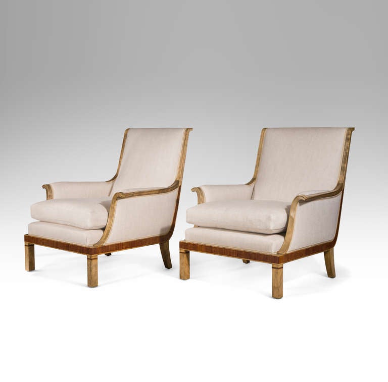 Belle synthèse de classicisme et de modernité, ces chaises sont aussi confortables qu'élégantes. La traverse supérieure à volutes se prolonge par des accoudoirs qui se déploient doucement, flanquant un coussin d'assise aux dimensions généreuses sur
