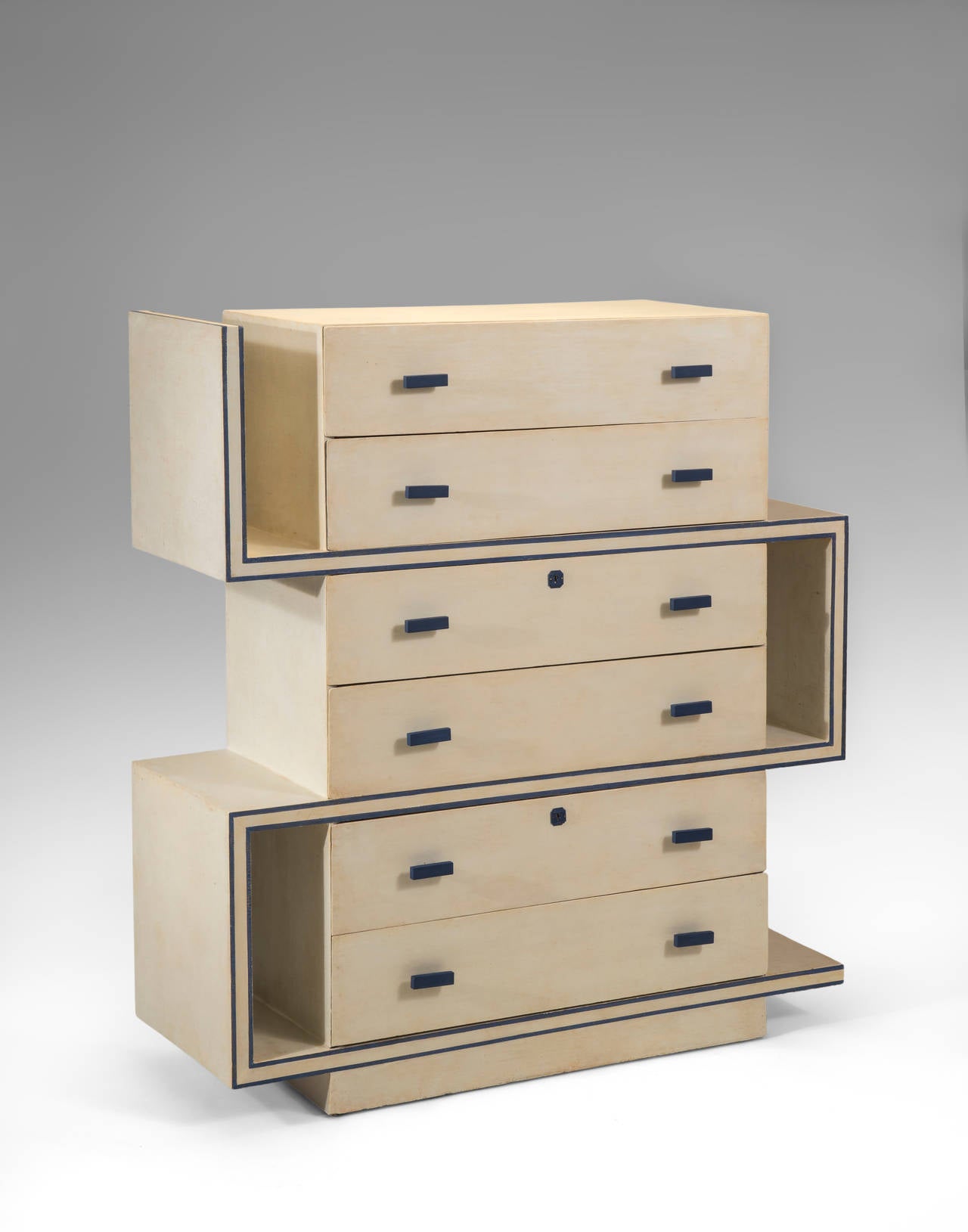 A highly unusual and sophisticated design. The rectangular top, above six drawers, each drawer with a pair of bakelite pulls, two drawers with locks and escutcheons, intersected by a double-banded key-form frame, terminating on a rectangular plinth.