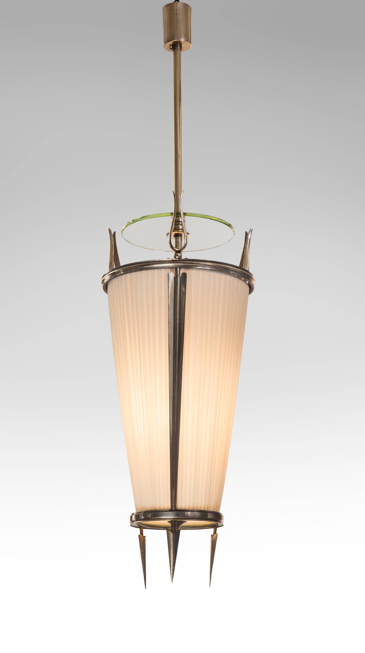 Each cylindrical canopy above a suspension rod centering a floating glass disc, the conical body with a fabric shade framed by stylized arrows.

The same model lantern is illustrated by P. Buffa and A. Cassi, Decoratori e Architetti Contemporanei,