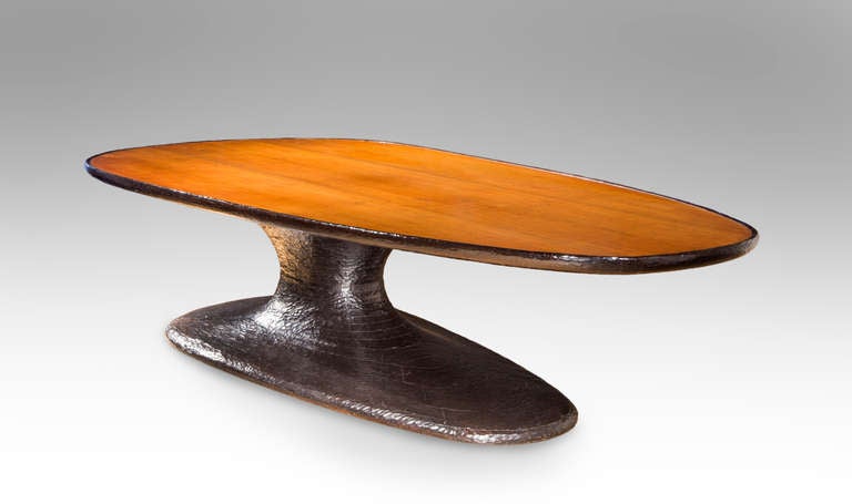 A monumental and documented unique work by one of the most important American designers of the twentieth century. The sculptural form, beautifully hand crafted, supporting an elliptical rosewood top, above a carved and ebonized mahogany pedestal