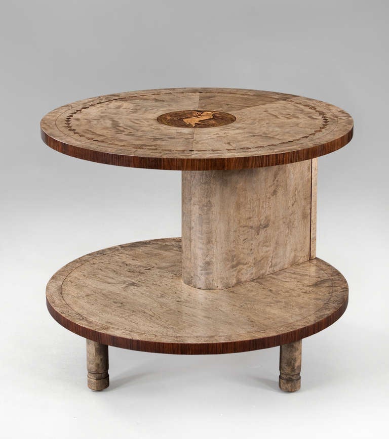 The circular top of radiating birch veneer with a bellflower border, centering a circular reserve depicting a female figure reclining on a chaise lounge in front of a tea table and surrounded by flowers, the figure in an empire dress with book on
