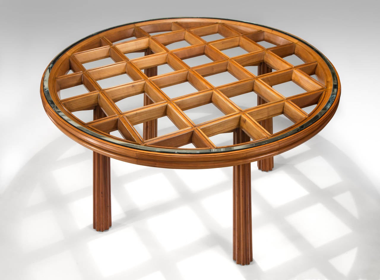The inset circular glass top with silvered banding, above a latticework frame and molded frieze, on fluted tapering legs.

A related table is illustrated by Giulana Gramigna and Fulvio Irace, Osvaldo Borsani, Leonardo-De Luca Editore, Rome, 1992,