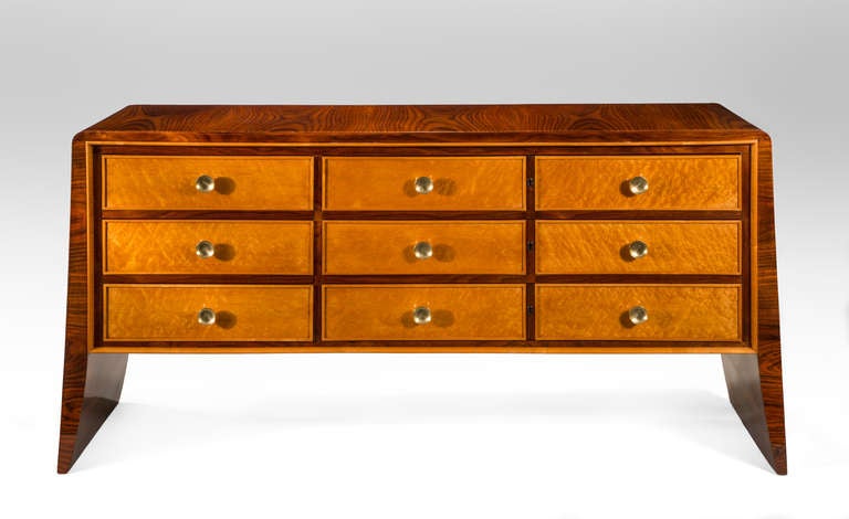 Attributed to Guglielmo Ulrich. The rectangular top and sides of highly figured rosewood, on solid tapering flared legs, enclosing a bank of six birdseye maple drawers each with a circular brass pull, an exquisitely cast original key included.