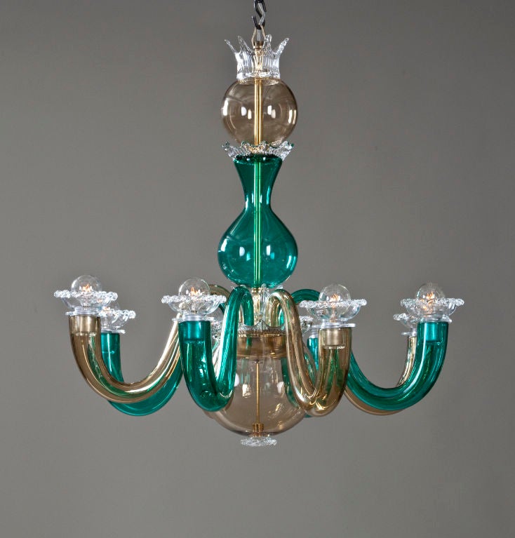 The baluster and spherical standard adorned in a series of crowns, issuing 8 s-shaped arms, each terminating in a wavy-edge cup-shaped light holder, of alternating smoke and teal colored glass with colorless glass accents.  <br />
<br />
A rare