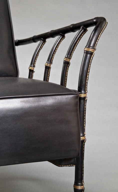 Mid-20th Century A Large Pair of Brass Mounted Leather Armchairs by Jacques Adnet