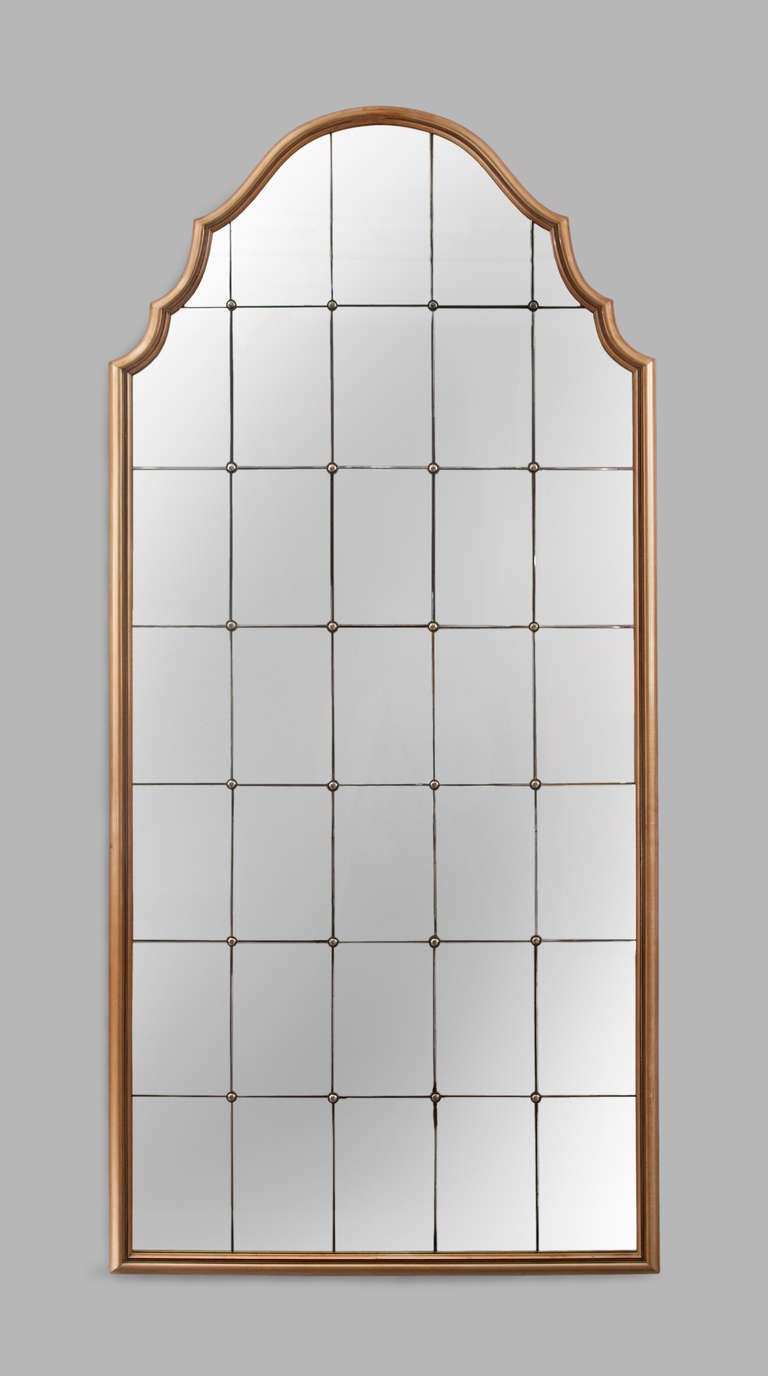 The arched molded frame inlaid with pewter and ebony banding, surrounding thirty-five conforming mirror plates joined by silvered paterae.

Accompanying cabinet available. 

Provenance:  The private residence of Paul Follot and then by decent.