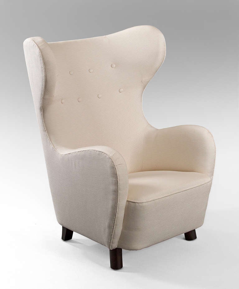 Comfortable, boldly proportioned, and generously scaled.  Upholstered throughout, the upturned curvaceous toprail descends in a sinuous line to form each arm, on cylindrical front legs and saber back legs.

Provenance: These chairs and variations