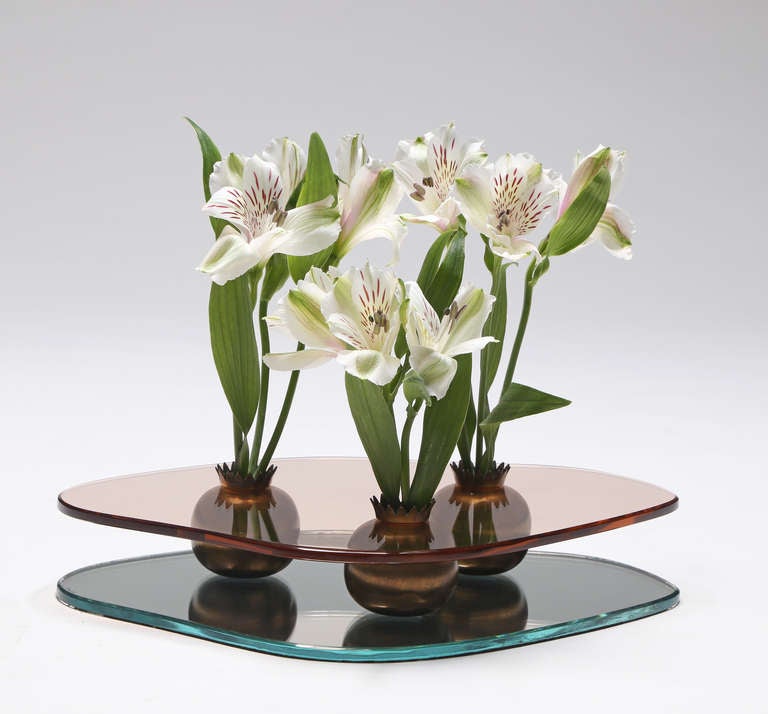 The gently shaped rosambrato glass top, raised on three stylized pomegranate vases / candle holders, on a conforming mirrored glass base. 

The same model vase is illustrated by Franco Deboni, Fontana Arte - Gio Ponti, Pietro Chiesa, Max Ingrand,