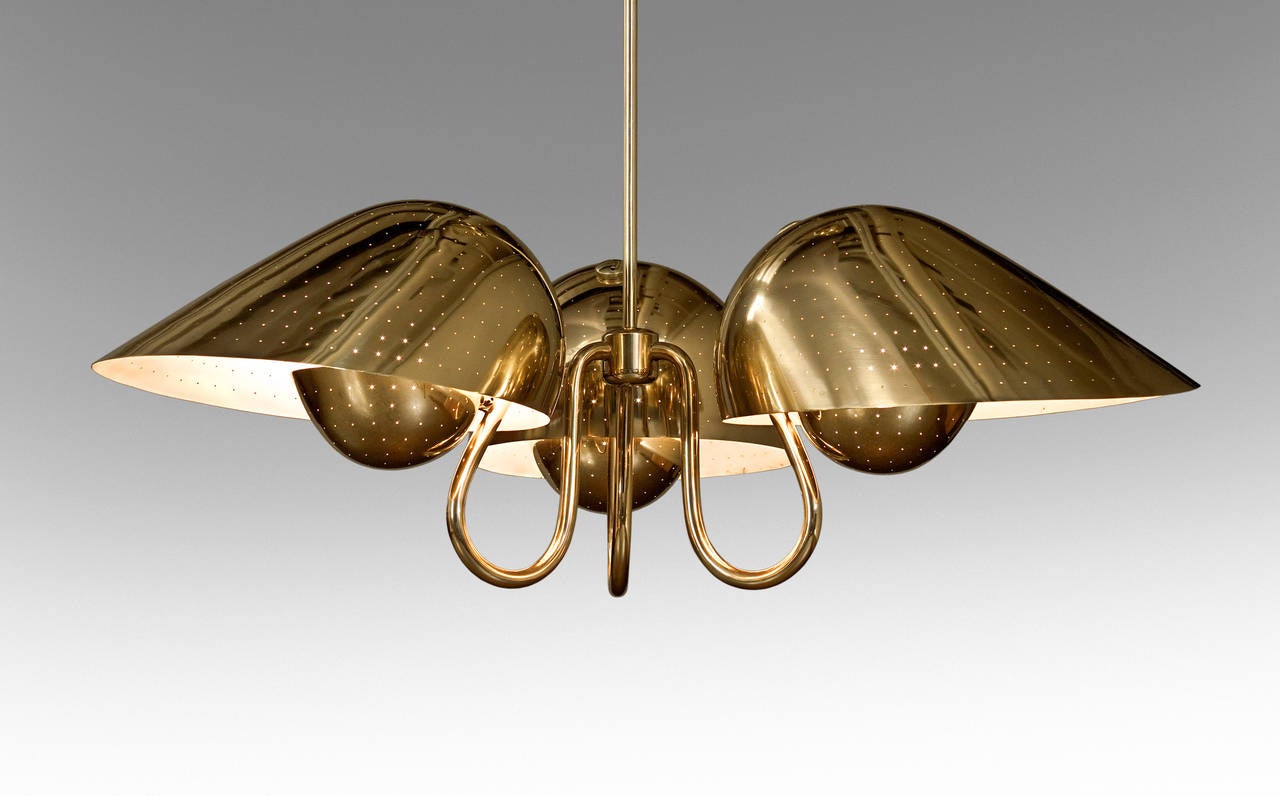 A beautifully balanced chandelier in excellent condition with all its original pieces in working order. The shaped canopy above an adjustable counterweight system, with three s-curved arms each issuing perforated two-tiered deflectors.  Minimum