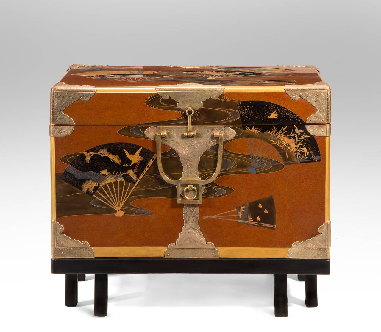 The superb lacquer work adorned with Japanese fans depicting naturalistic worlds and classical motifs including chidori, sparrows, cranes, and butterflies, each fan floating over a meandering stream, the rectangular lid fitted to a conforming base,