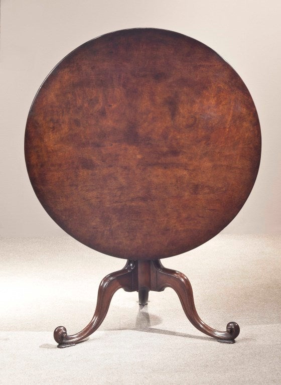 A fine quality mahogany tripod tea table in the manner of Thomas Chippendale, the top being of an extraordinary piece of mahogany having a plain stem on carved legs terminating in scroll toes. 
Height: 27 5/8” Diameter: 36 1/3”