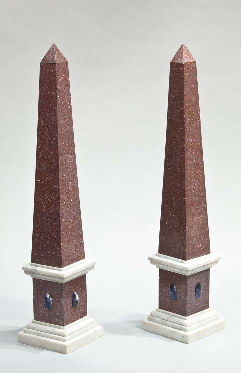 A pair of large, porphyry veneered obelisks with white marble mouldings on the base and four applied oval lapis lazuli medallions. Italian, Early 20th Century